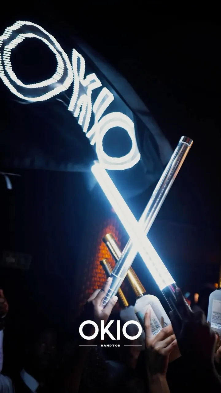 Neon OKIO sign over the crowd